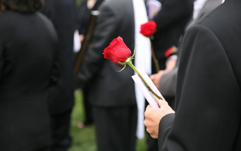 Single red rose at a funeral part of a feature on grief